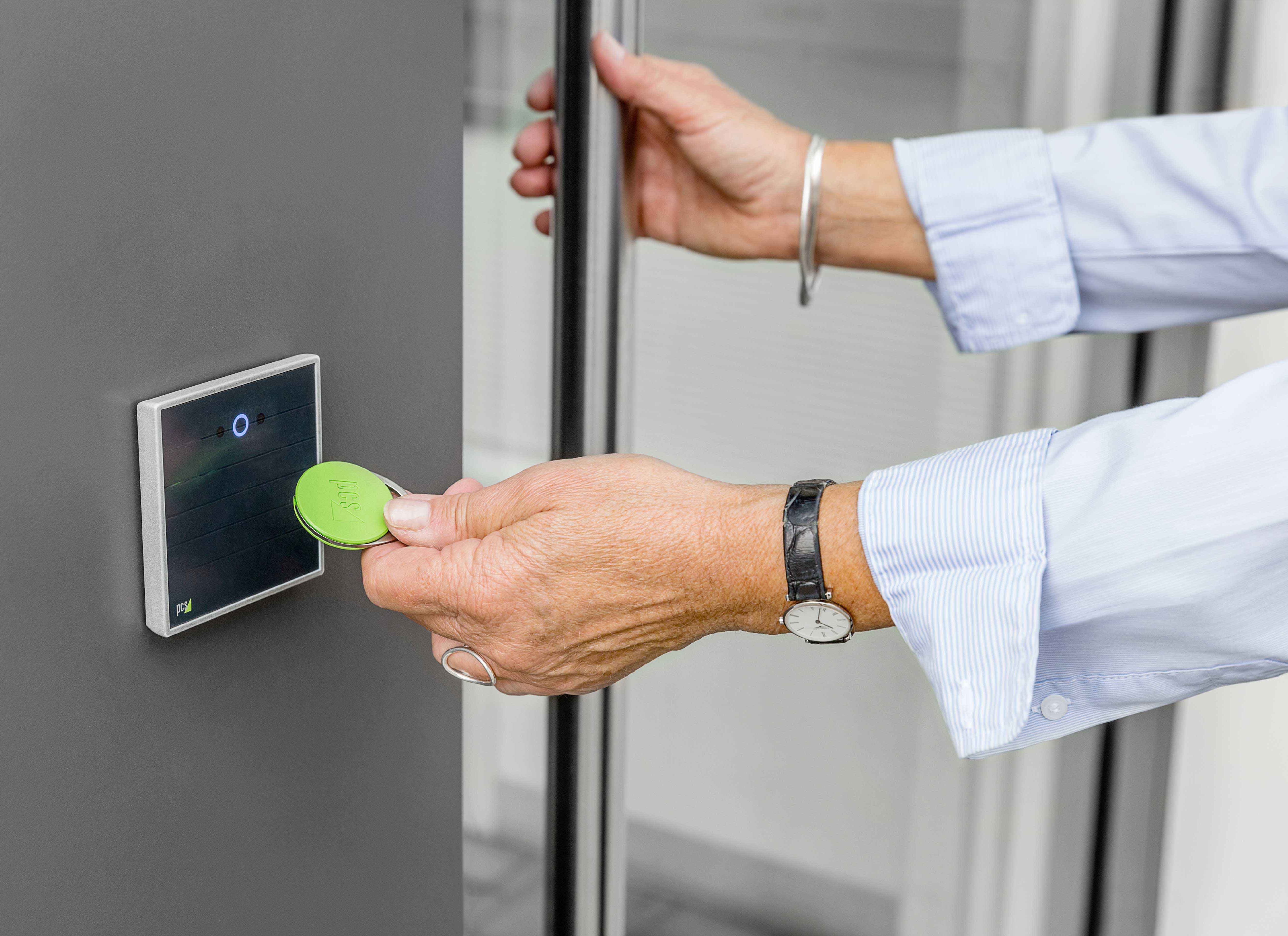 Hand mit RFID-Transponder an RFID-Zutrittsleser INTUS 620