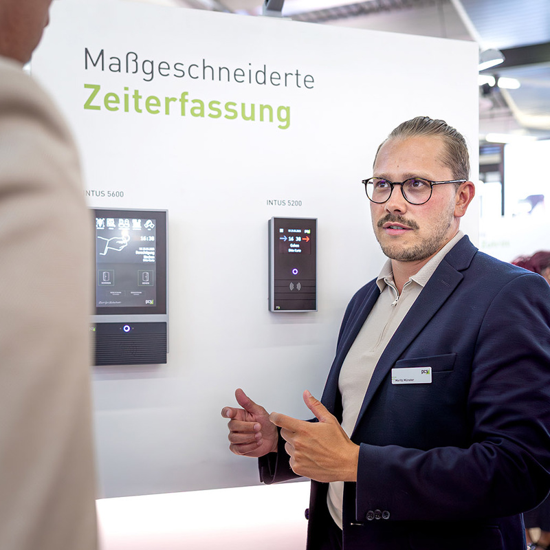 PCS Service Planung und Beratung Personen im Gespräch auf Messestand