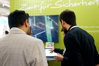 Das Bild zeigt Besucher, die sich auf der SicherheitsExpo über die PCS Lösungen informieren.