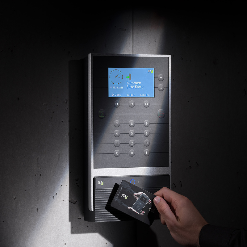 Zeiterfassungsterminal INTUS 5540 mit Schatten und Hand, die mit Karte Zeit erfasst