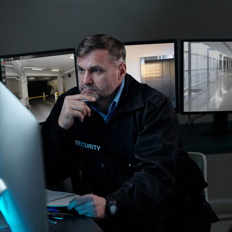 Sicherheitsdienst-Mitarbeiter vor Monitor