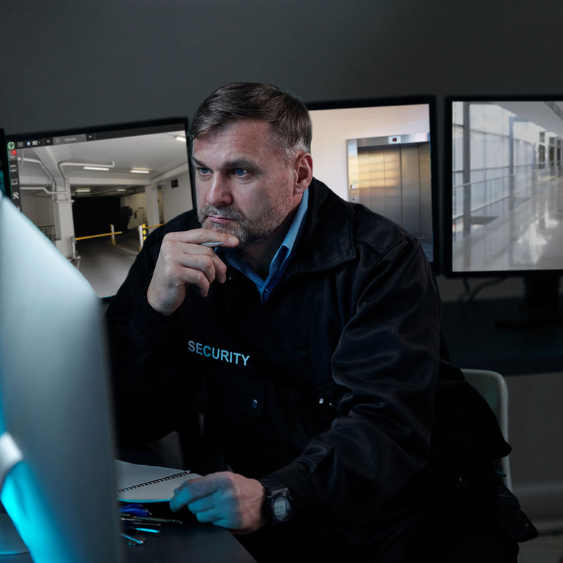 Sicherheitsdienst-Mitarbeiter vor Monitor