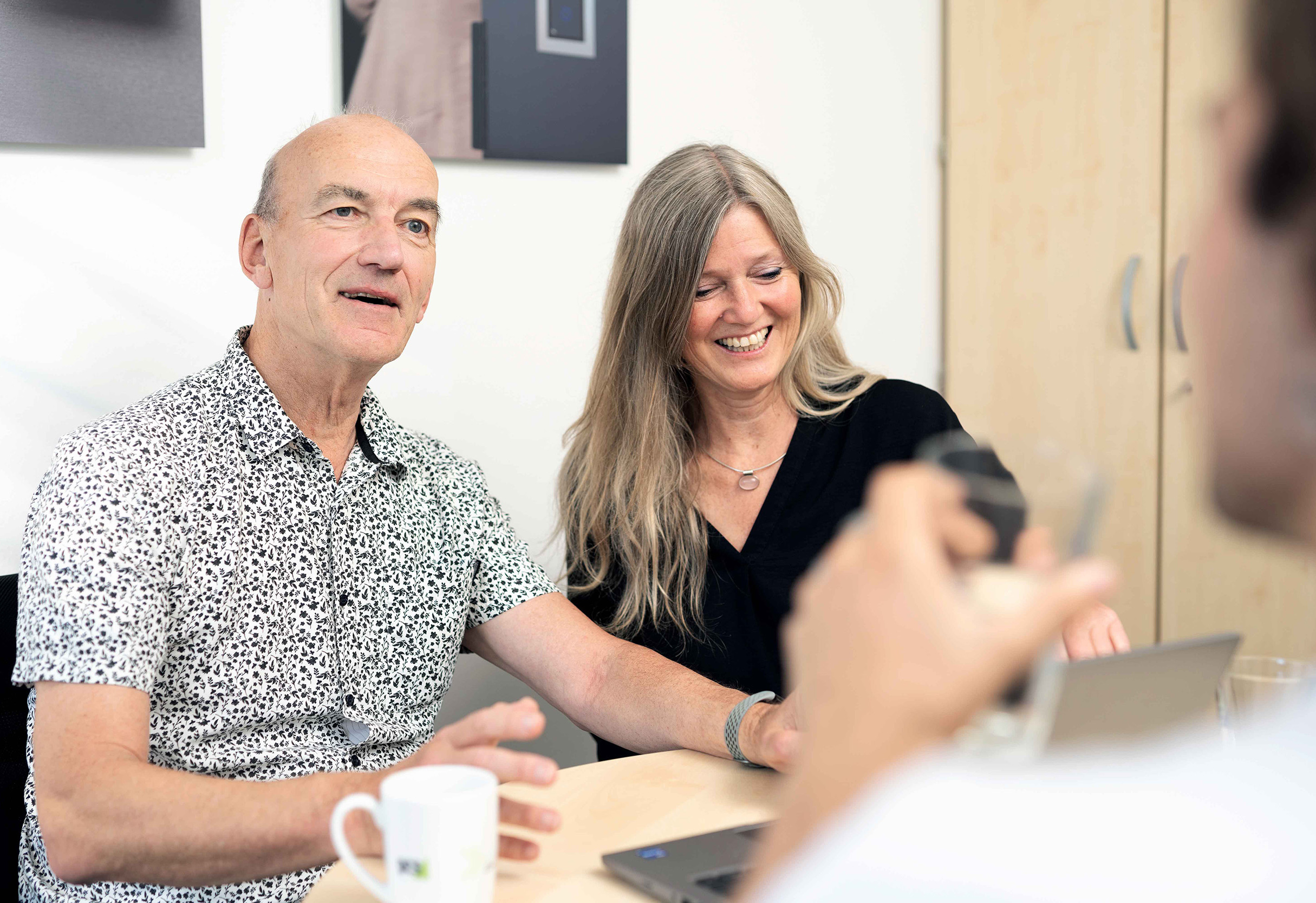 Personen besprechen sich vor Laptop