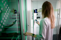 Smartphone mit virtuellem Mitarbeiterausweis wird an Leser gehalten