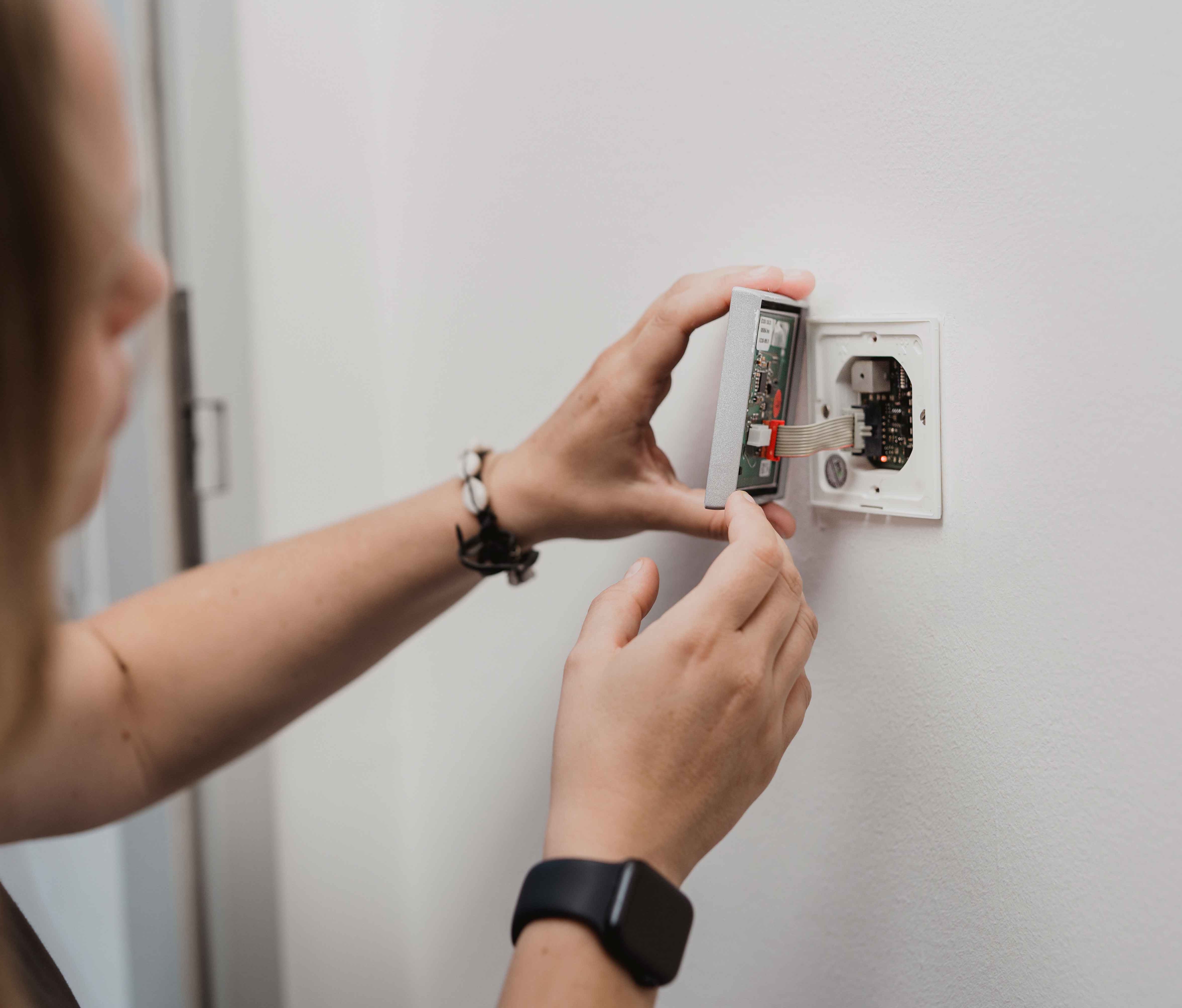 Servicemitarbeiter bringt INTUS Gerät an Wand an