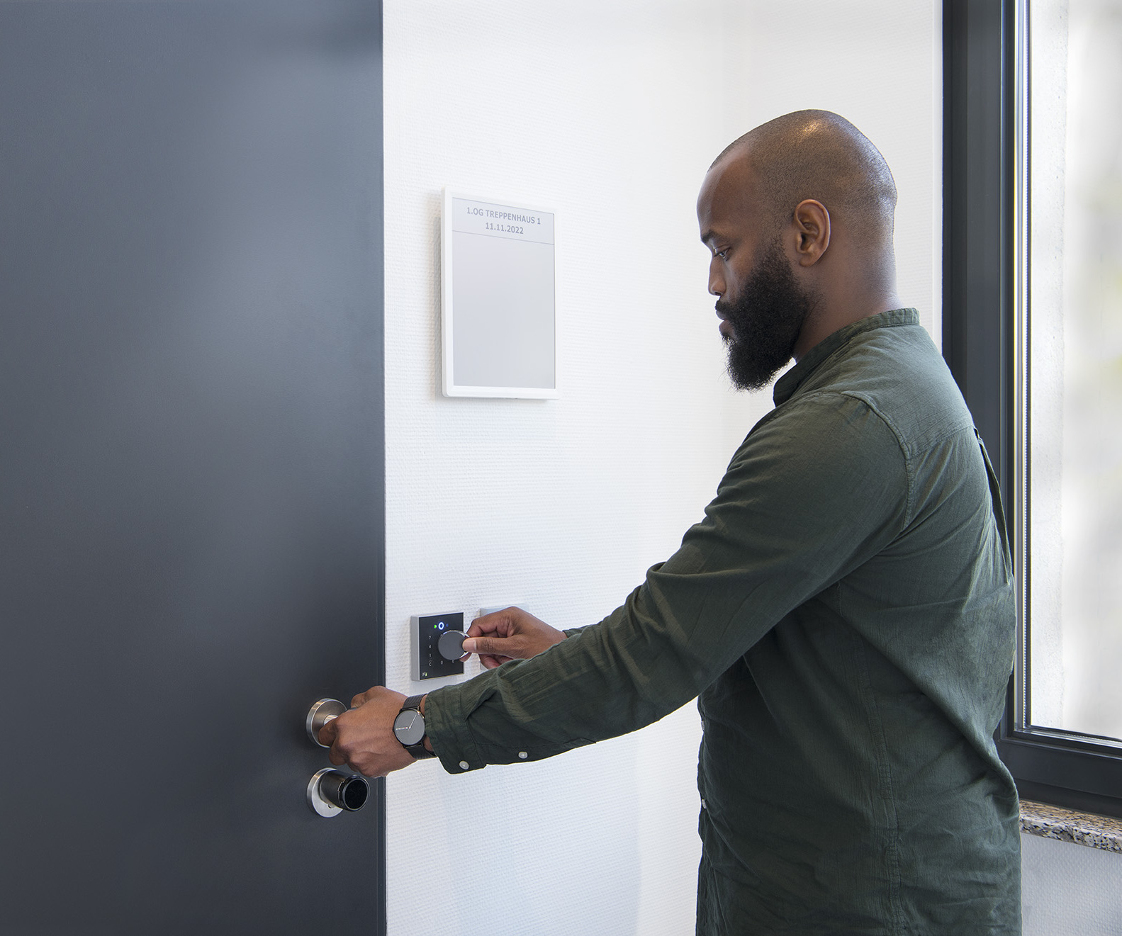 Männliche Person bedient Zutrittsleser mit RFID-Medium