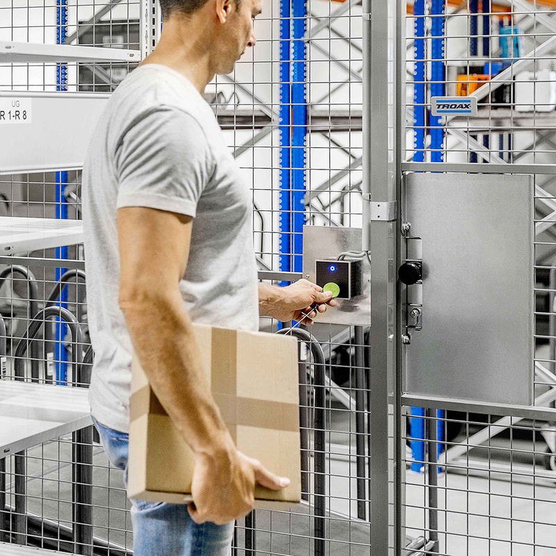 Person betritt Lagerraum mittels Zutrittsleser INTUS 620 