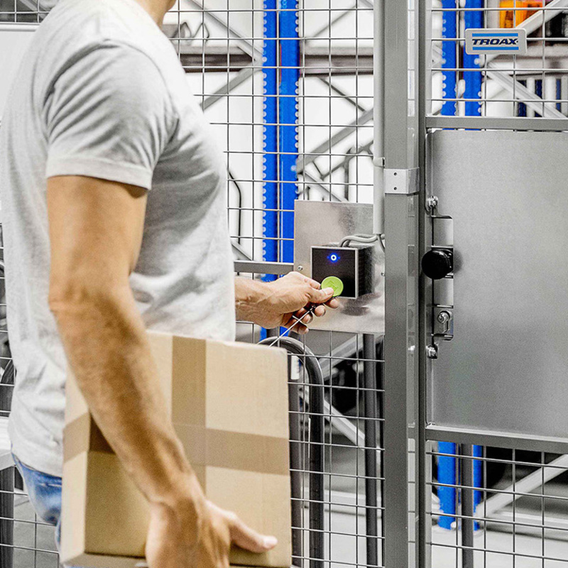 Person betritt Lagerraum mittels Zutrittsleser INTUS 620 