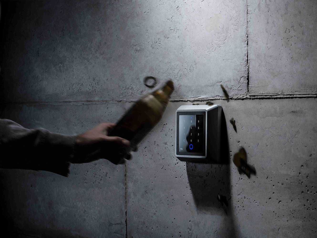Schlag mit Flasche auf Zutrittsleser INTUS 700steel an Wand montiert
