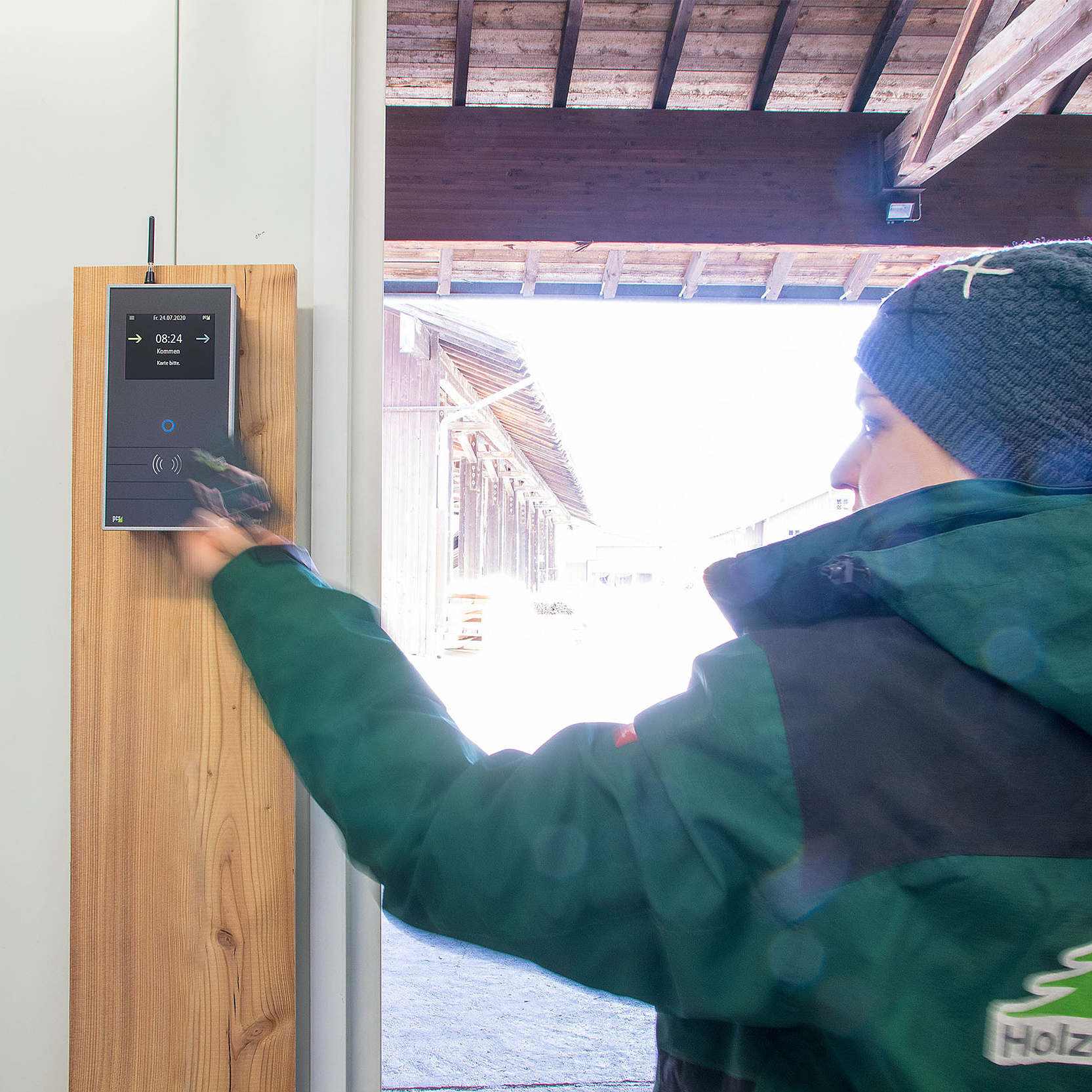 Frau erfasst Arbeitszeit an Zeiterfassungsterminal INTUS 5200 mit Mobilfunkantenne