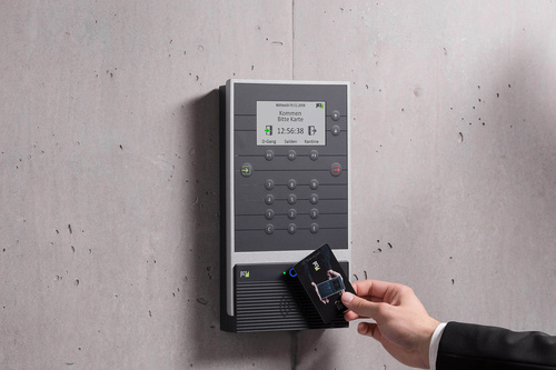 Hand with RFID card books the working time at the INTUS 5540 time recording terminal.